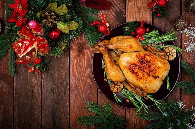 Mesa navideña servida con pavo, decorada con brillantes guirnaldas y velas.