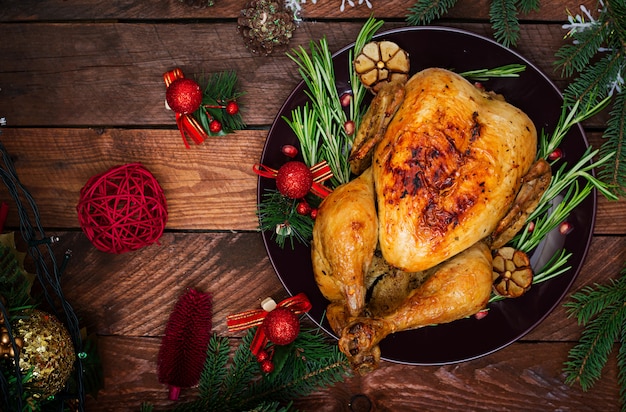 Mesa navideña servida con pavo, decorada con brillantes guirnaldas y velas.