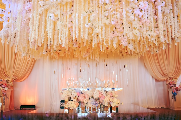 Mesa de novios y novias decorada con flores y velas.