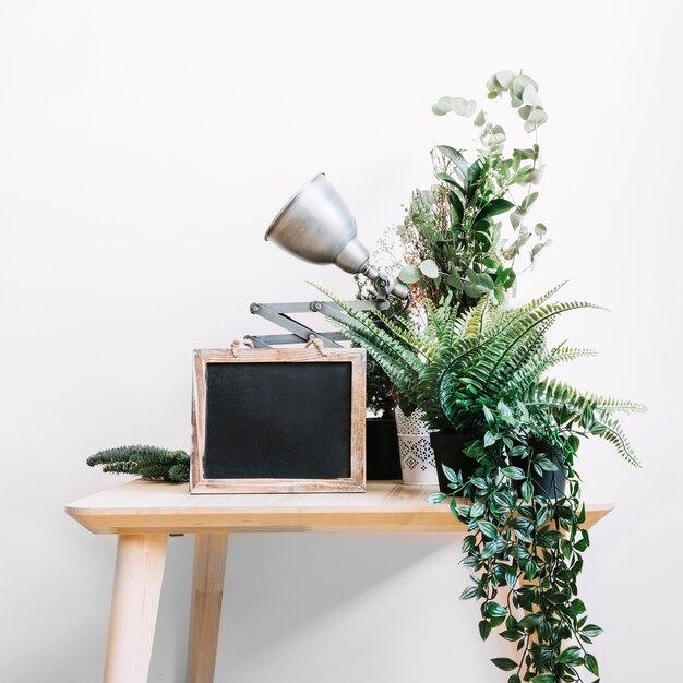 Mesa con pizarra, lámpara y plantas