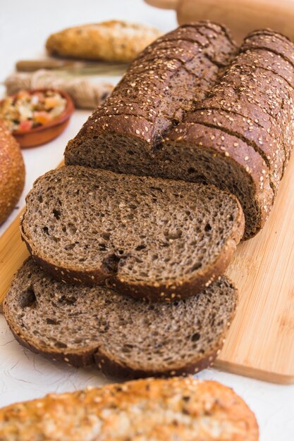 Mesa con rebanadas de pan en la tabla de cortar