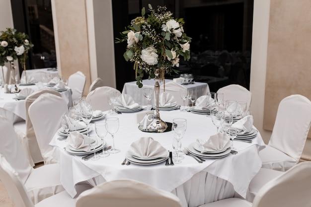 Mesa redonda blanca servida con un centro de mesa floral en el restaurante