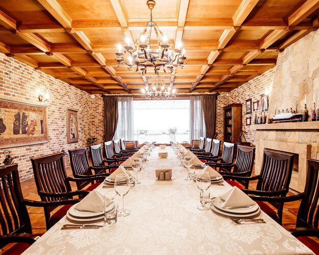 Mesa de restaurante en la sala privada con chimenea, techos de madera y paredes de ladrillo.