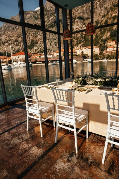 Mesa romántica para la recepción de bodas con vistas al mar a través de las ventanas