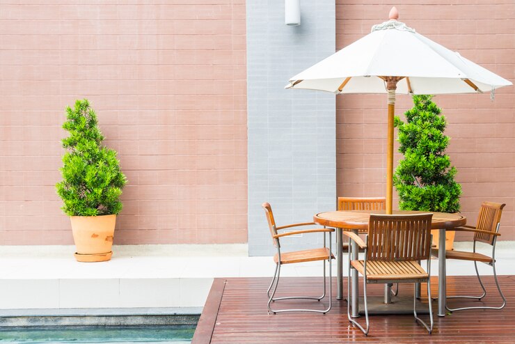 Foto gratuito mesa y silla con sombrilla blanca, patio exterior.