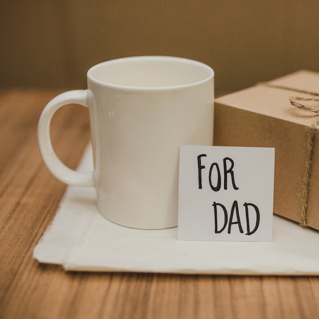 Foto gratuita mesa con taza y regalo para el día del padre