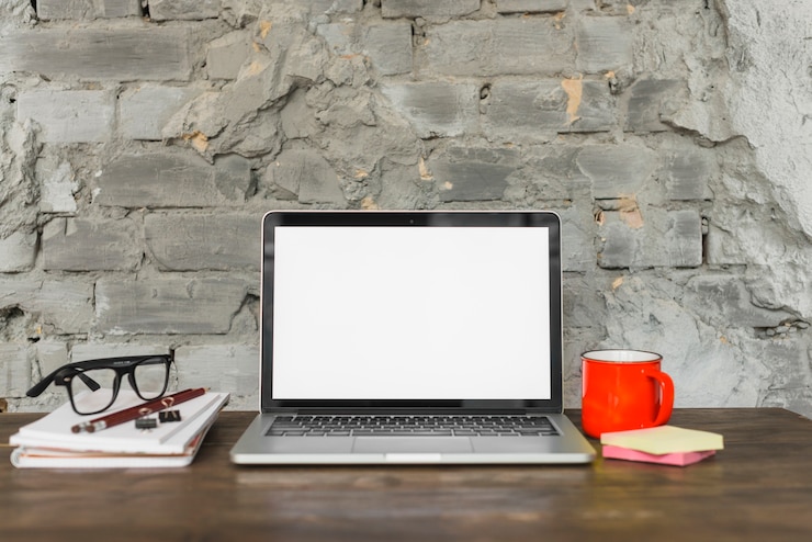 Foto gratuito mesa de trabajo dispuesta con laptop; espectáculo; taza de café roja y suministros de oficina