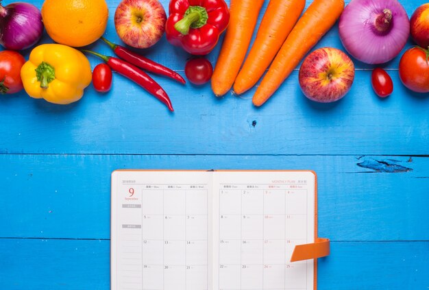 Mesa con verduras y una agenda