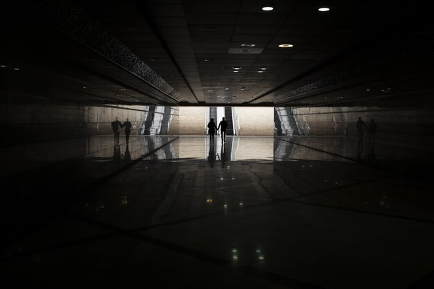 Foto gratuita metro oscuro con gente caminando en la distancia