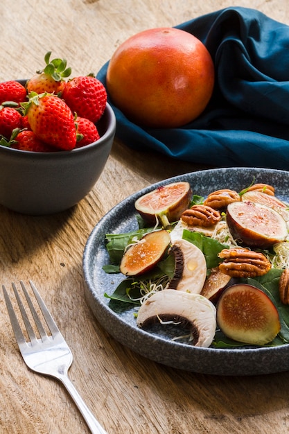 Mezcla de alto ángulo de higos y nueces en plato con fresas