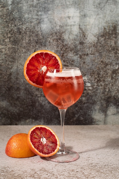 Mezcla de cócteles en copas con cubitos de hielo y naranja sanguina