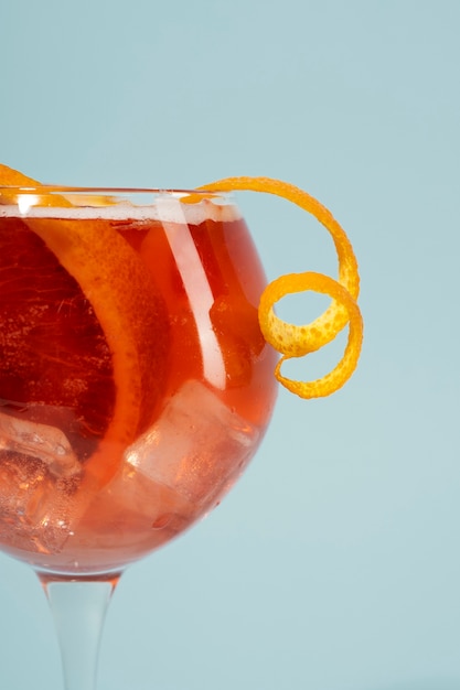 Mezcla de cócteles en copas con cubitos de hielo y naranja sanguina