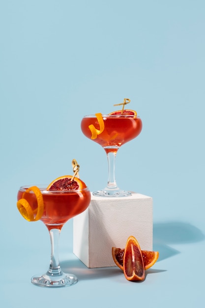 Mezcla de cócteles en copas con cubitos de hielo y naranja sanguina