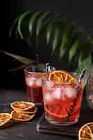 Foto gratuita mezcla de cócteles en copas con fruta de naranja