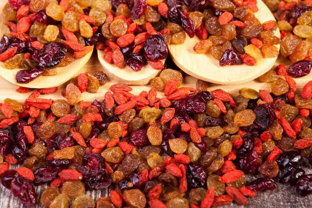 Mezcla de frutos secos dulces en cuchara de madera sobre fondo de madera en foto de estudio. Estilo de vida saludable