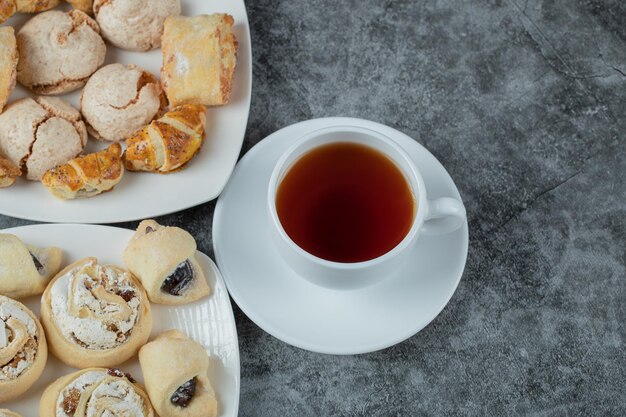 Mezcla de galletas en bandeja servidas con una taza de té Earl Grey.