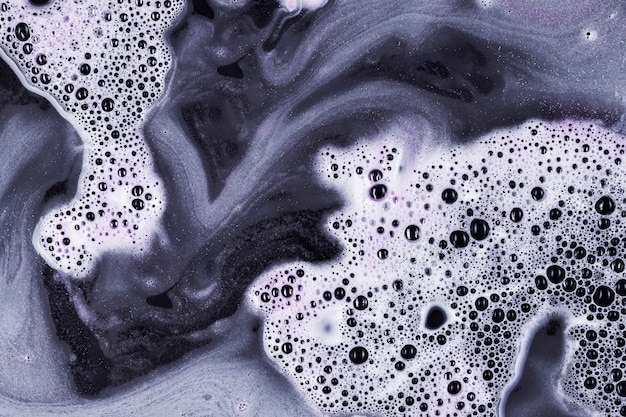 Mezcla de líquido blanco y negro con espuma y burbujas.
