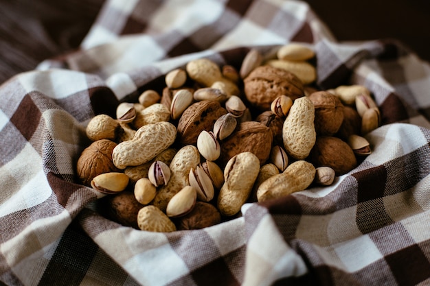 Mezcla de nueces en la toalla. Grupo de diferentes frutos secos: maní, pistacho, nueces. Nueces orgánicas