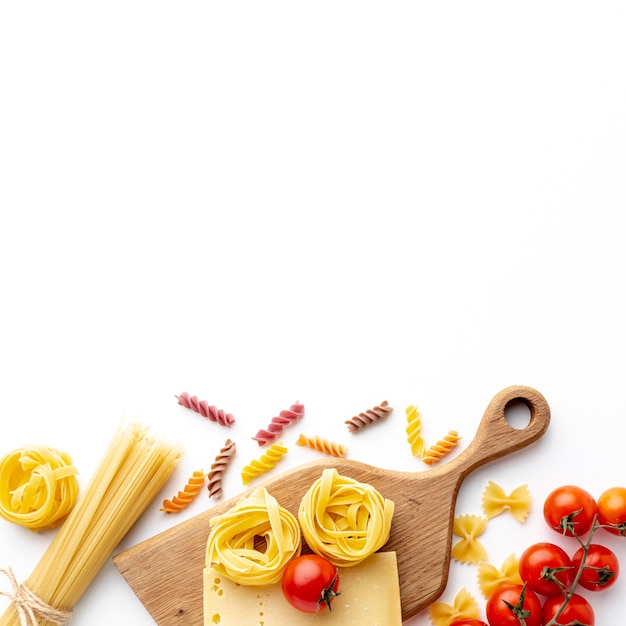 Mezcla de pasta cruda, tomates y queso duro con espacio de copia