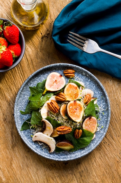 Mezcla plana de nueces e higos en un plato con fresas