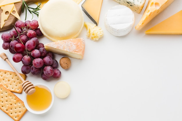 Foto gratuita mezcla plana de queso gourmet y uvas con espacio de copia