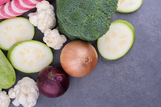 Mezcla de verduras con diversos alimentos aislados en superficie azul