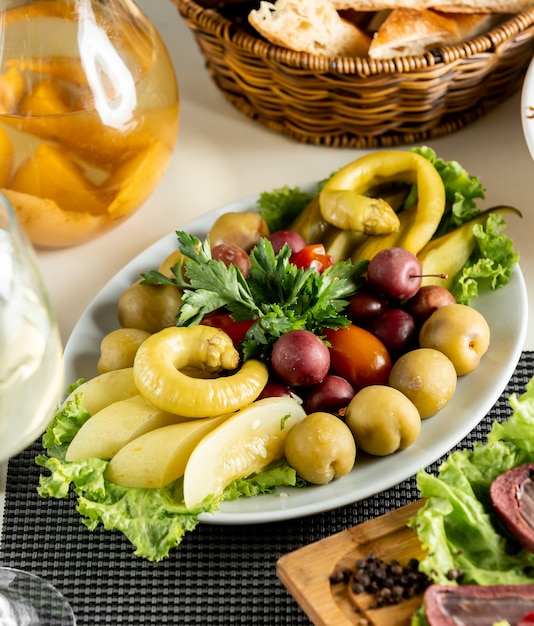 Mezcla de verduras y frutas marinadas dentro de un plato blanco.