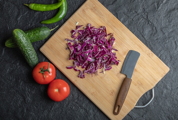 Mezcla de verduras. Repollo picado, pepino, tomate y pper sobre fondo negro