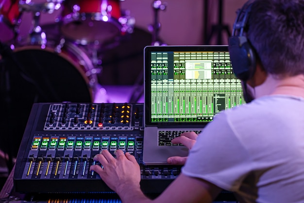 Mezclador digital en un estudio de grabación, con una computadora para grabar música. En el fondo del ingeniero de sonido en el trabajo. El concepto de creatividad y espectáculo.