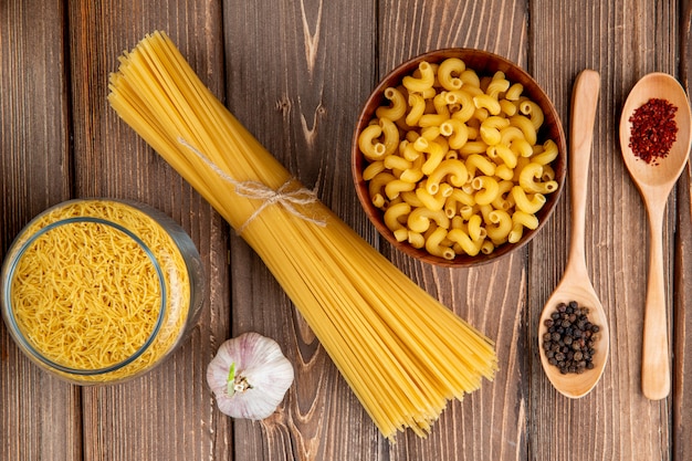 Mezclar pastas en la mesa de madera espaguetis fellini chifferi ajo sumakh pimienta vista superior