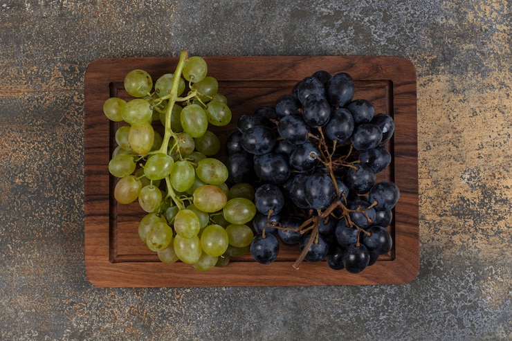 Foto gratuito mezclar uvas frescas sobre tabla de madera.
