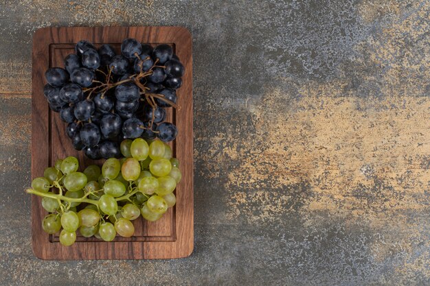 Mezclar uvas frescas sobre tabla de madera.