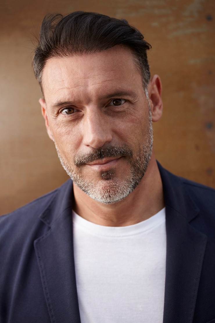 Photo Gratis middle-aged man wearing leaning against a rusty colored background