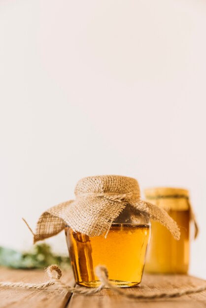 Miel fresca en frasco cerrado sobre superficie de madera