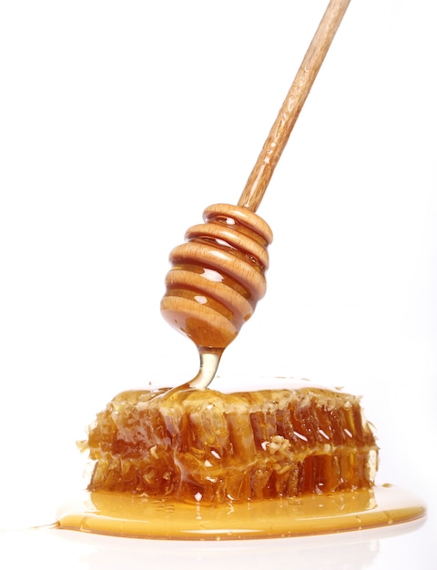 Miel goteando de una cuchara de madera