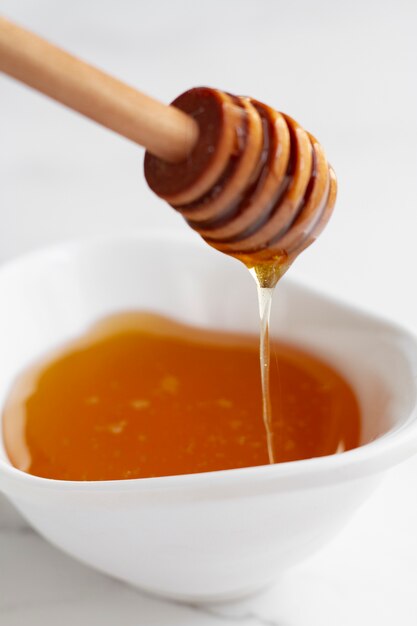 Miel en un tazón con cucharón de madera para miel