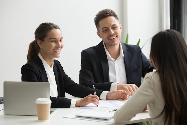 Miembros amistosos del equipo charlando riendo juntos durante las vacaciones de oficina