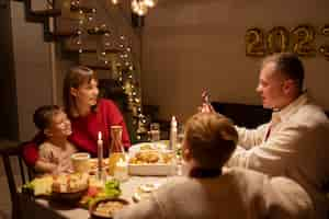 Foto gratuita miembros de la familia sentados en la vista lateral de la mesa