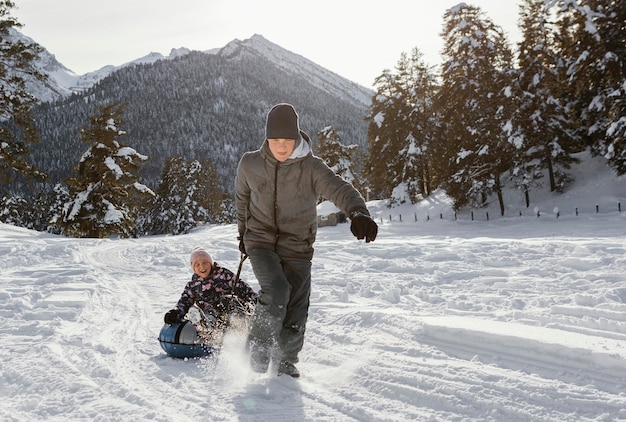 Miembros de la familia de tiro completo jugando en la nieve