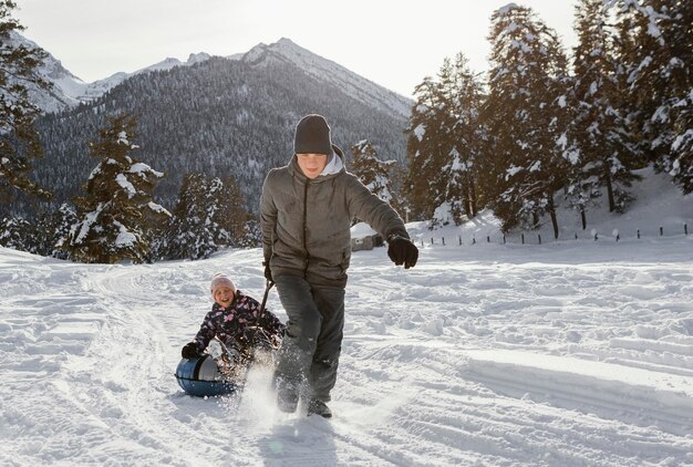 Miembros de la familia de tiro completo jugando en la nieve