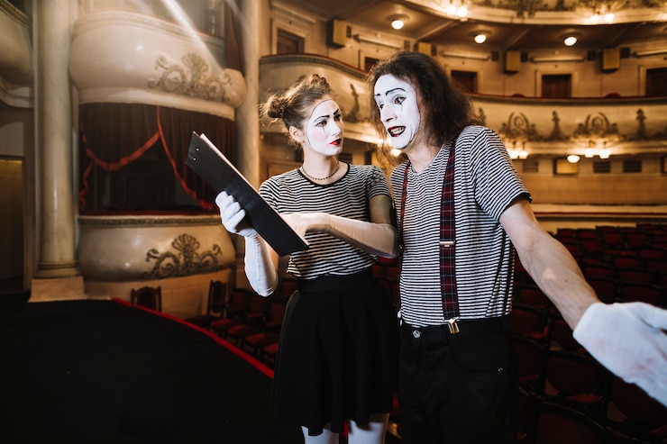 Foto gratuito mime femenino que ayuda al mimo masculino mientras se realiza en el escenario