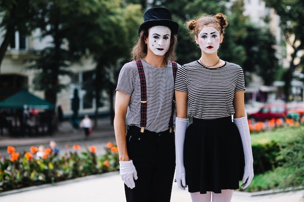 Foto gratuita mime pareja de pie en el jardín