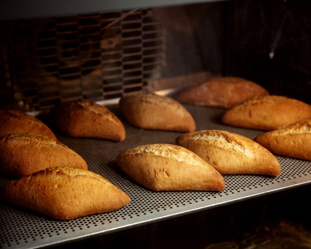 Mini bollos de pan en forma de romb listos en el horno