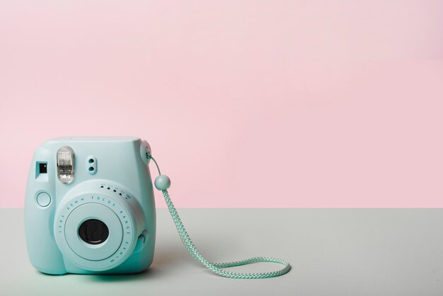 Mini cámara instantánea de moda contra el fondo rosa