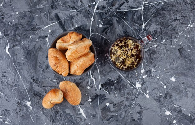 Mini croissants de hojaldre con costra dorada y una taza de té.