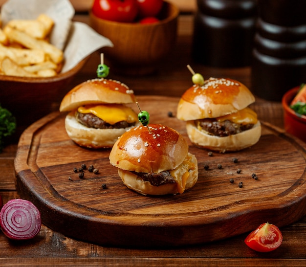 Mini hamburguesas sobre tabla de madera