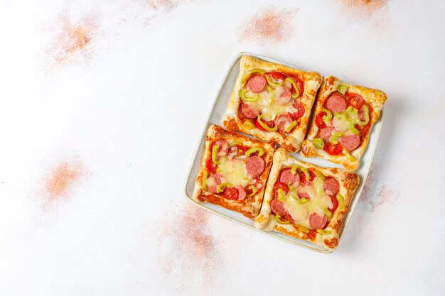 Mini pizzas de hojaldre con salchichas.