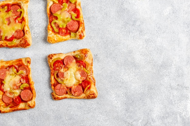 Mini pizzas de hojaldre con salchichas.