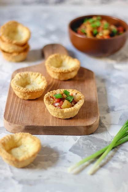 Mini tartas vacías en tabla de cortar, proceso de fabricación