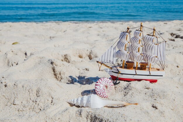 Foto gratuita miniatura del barco en la playa tropical